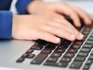 Mains de jeunes tapant sur un clavier